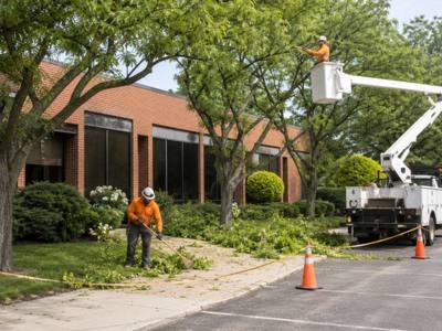 Bucket truck parked outside a commercial building with cones marking the work area
